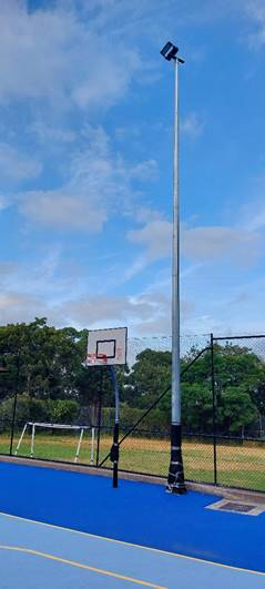 A basketball hoop and a light post

Description automatically generated