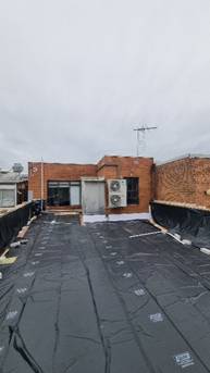 A brick building with a black tarp

AI-generated content may be incorrect.