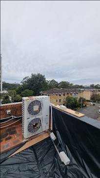 A white air conditioner on a roof

AI-generated content may be incorrect.