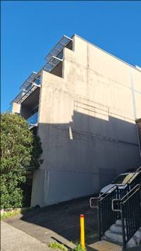 A building with a railing and a tree

AI-generated content may be incorrect.
