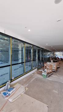 A long hallway with glass windows

AI-generated content may be incorrect.