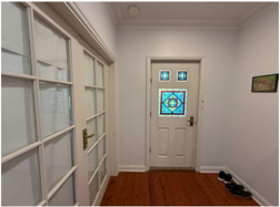 A hallway with a door and glass windows

AI-generated content may be incorrect.