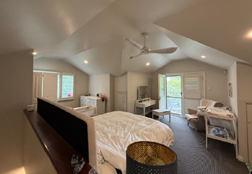 A bedroom with a bed and a ceiling fan

AI-generated content may be incorrect.