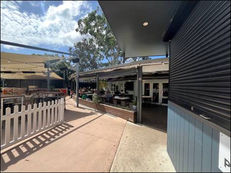 A building with a white fence and tables outside

AI-generated content may be incorrect.